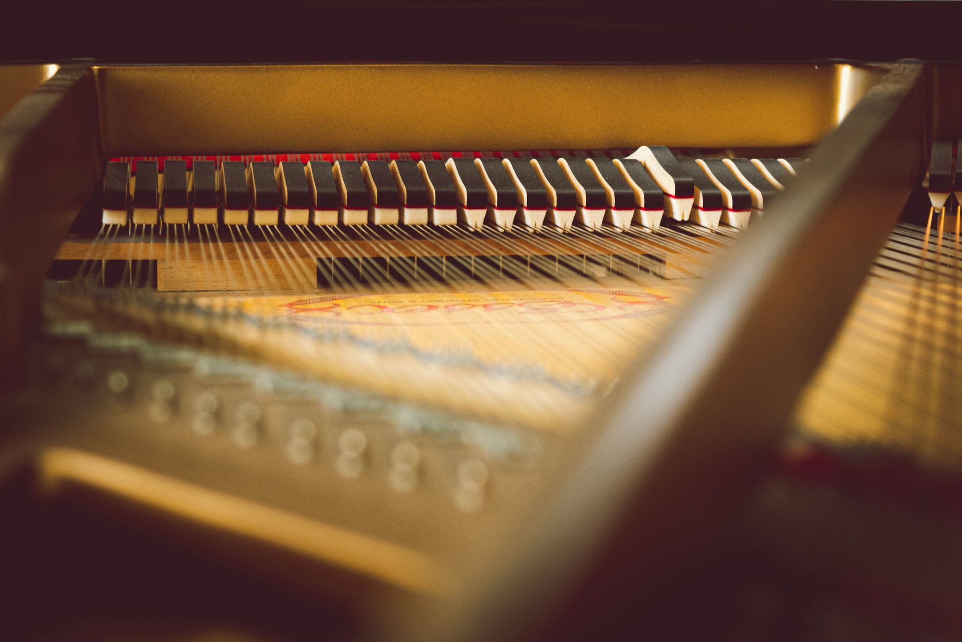 Detailed view of piano strings and mechanics inside a grand piano.